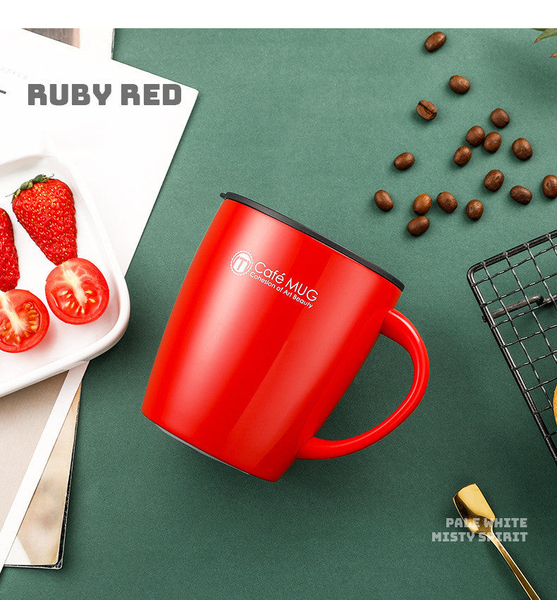 Red mug with a brand logo on a green surface with strawberries and coffee beans.