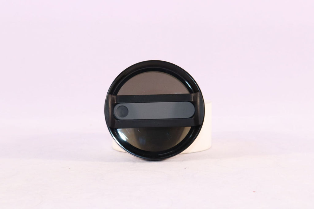 Black circular lid with a reflective surface on a white background