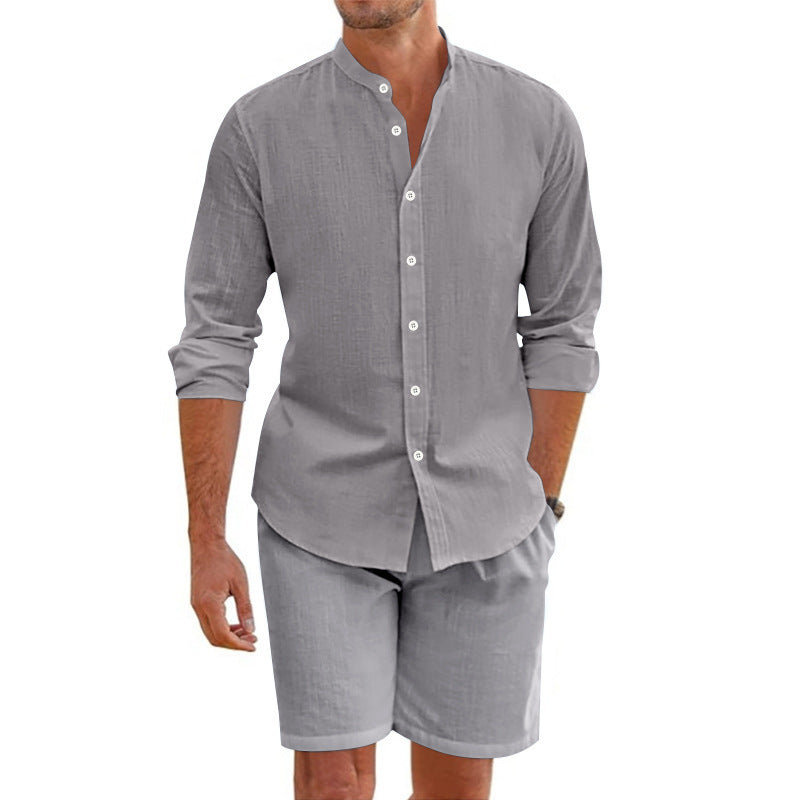 Man wearing a gray button-up shirt and shorts set on a white background
