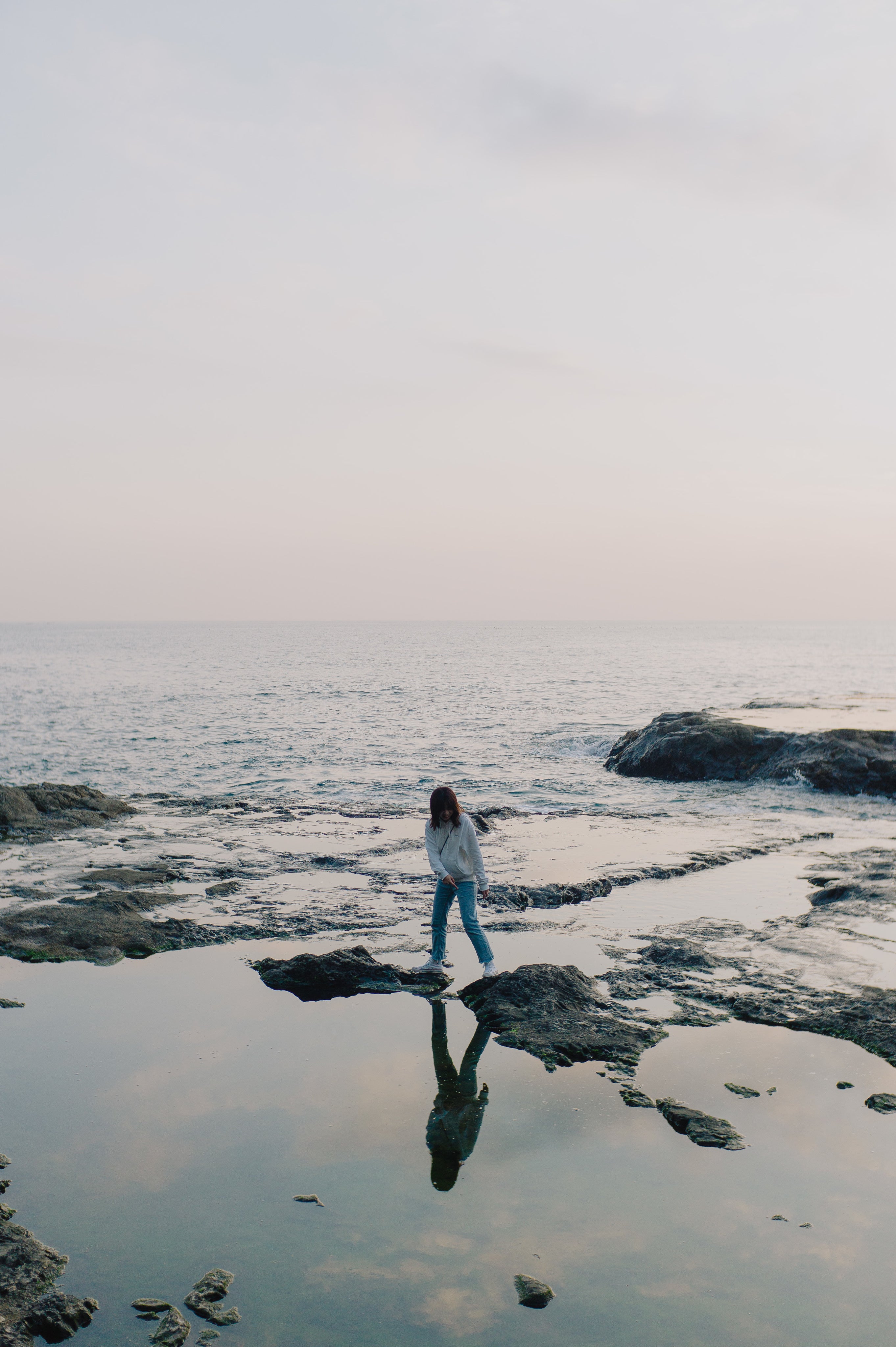 person standing on the rocks on shoreline